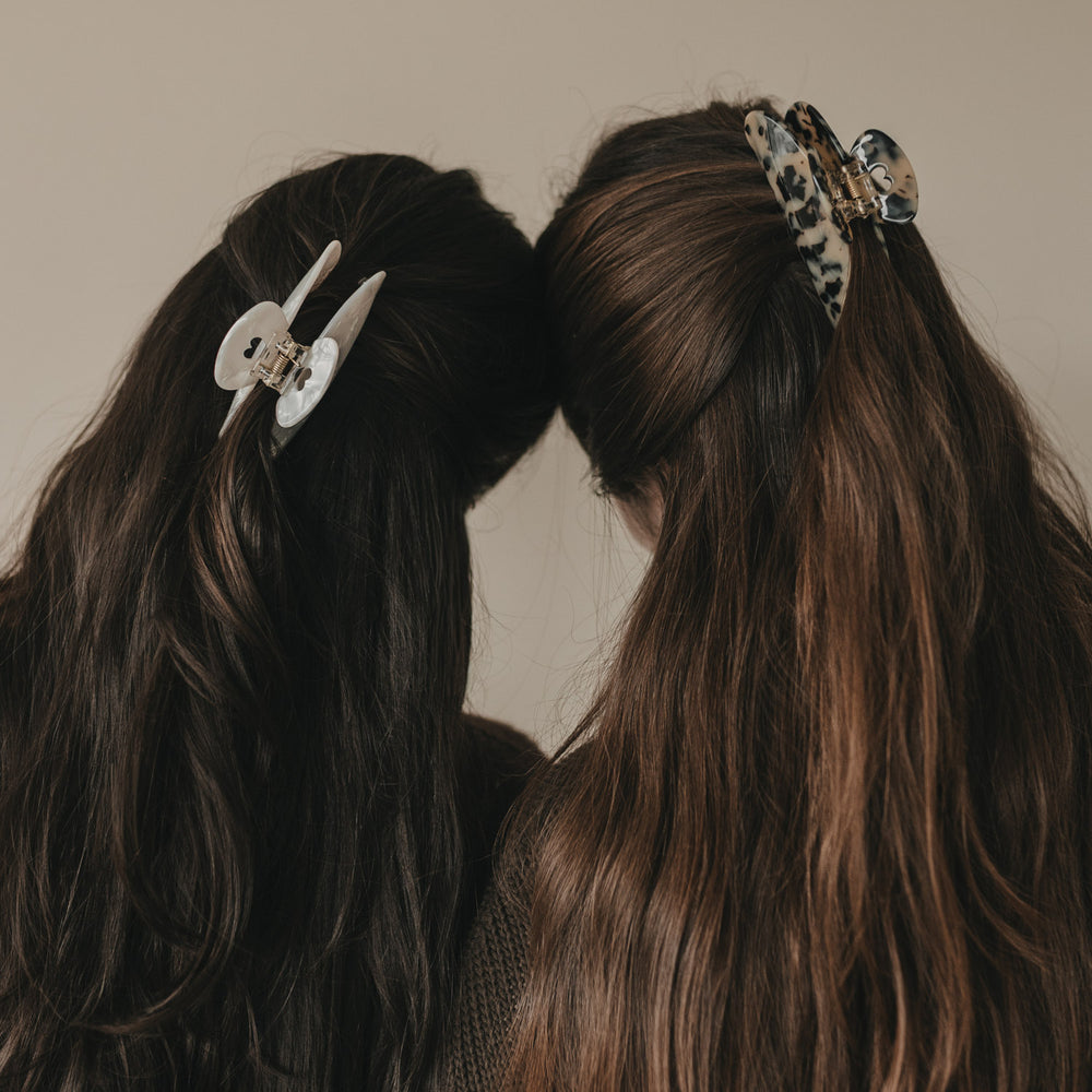 Zwei Frauen mit Haarspangen, eine Maxi Herz Leo und eine helle Variante, im Vergleich.