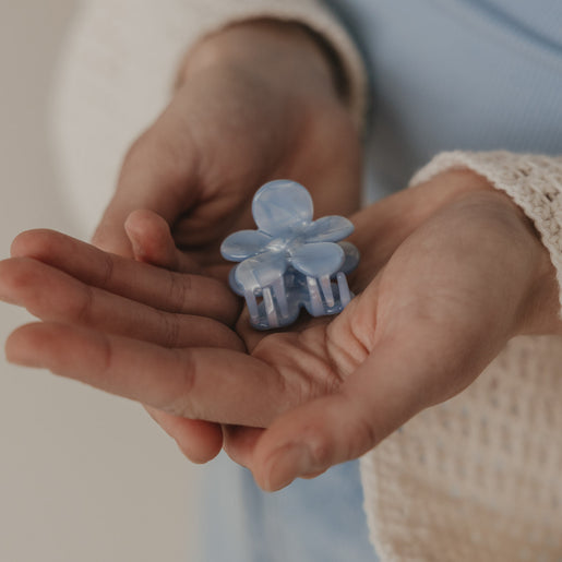 Haarspange Blume hellblau in den Händen präsentiert