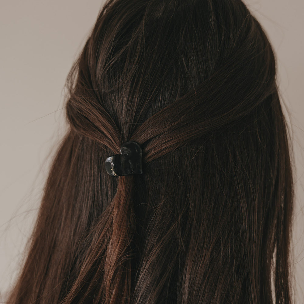 Rückansicht kleine Haarspange in Herzform schwarz im halboffenen Haar
