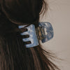 Detailaufnahme kleine blaue Haarspange mit Herzöffnung im Haar