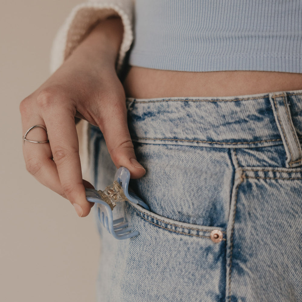 Kleine blaue Haarspange als Accessoire an Jeans getragen