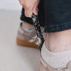 Detailaufnahme Schuhanzieher im Leo-Look beim Anziehen von Schuhen, funktionales und stilvolles Zubehör