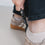 Detailaufnahme Schuhanzieher im Leo-Look beim Anziehen von Schuhen, funktionales und stilvolles Zubehör