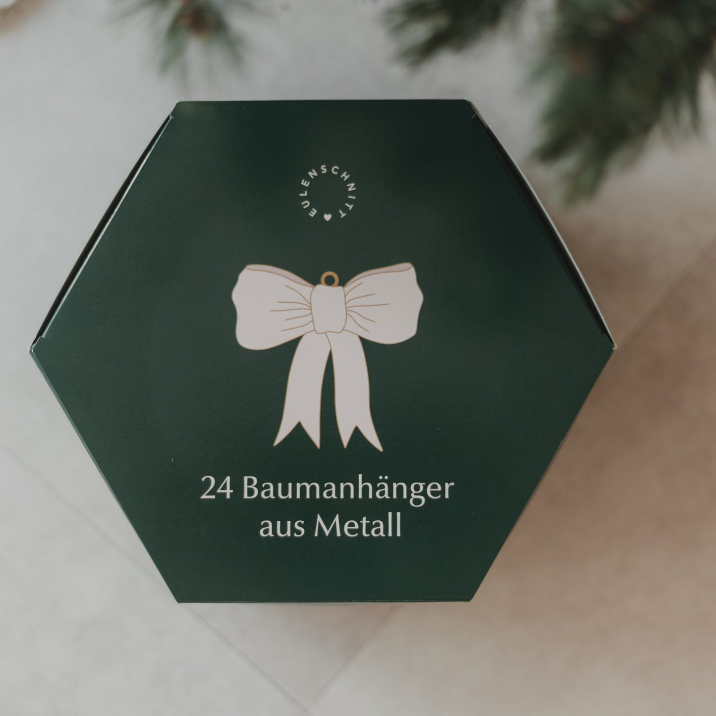 Oberseite des grünen Eulenschnitt Adventskalenders mit Schleifenmotiv und 24 Baumanhängern aus Metall