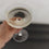 Hand hält Champagnerglas mit Gravur „Auf das Leben“ in Nahaufnahme, Fokus auf Glasboden.