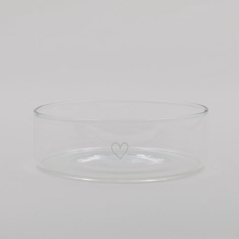 Transparente Glas-Schale mit zartem Herzmotiv, schlicht und minimalistisch vor hellem Hintergrund.