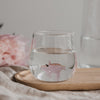 Trinkglas mit Schwein Motiv gefüllt mit Wasser auf Holzbrett, stilvolles Glas