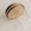 Nahaufnahme des leeren Vorratsglases mit kleinen schwarzen Herzen und Holzdeckel.