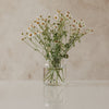 Glasvase mit Herzmotiv, gefüllt mit Blumenstrauß aus Kamille