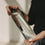 Trinkflasche aus Glas mit Herzmuster, schräg gehalten, modernes Design, Nahaufnahme in der Hand