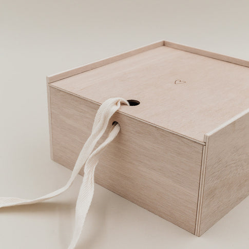 Nahaufnahme des geschlossenen Deckels der Erinnerungsbox Herz, durchzogen von einem Stoffband.