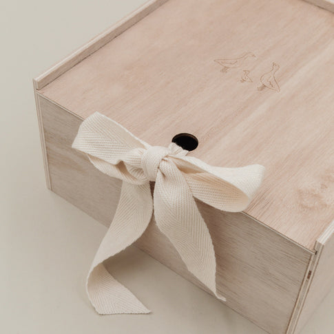 Detailfoto des Schleifenbands an der Holz-Erinnerungsbox mit feiner Gänsegravur auf dem Deckel.