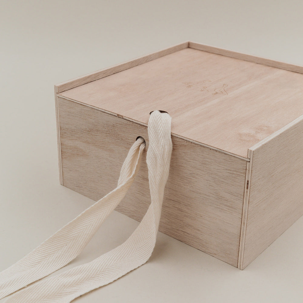 Detailaufnahme der Holz-Erinnerungsbox mit Stoffband, das durch die Seitenöffnung geführt ist.