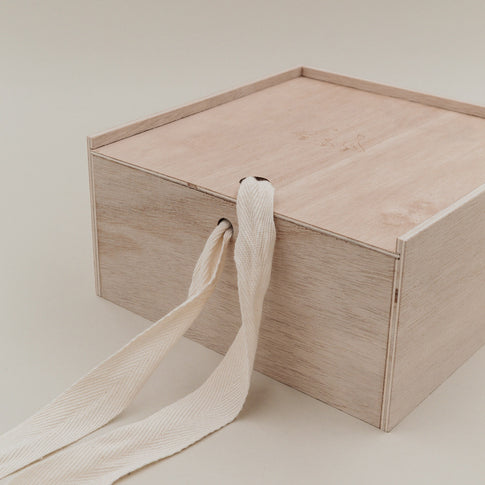 Detailaufnahme der Holz-Erinnerungsbox mit Stoffband, das durch die Seitenöffnung geführt ist.