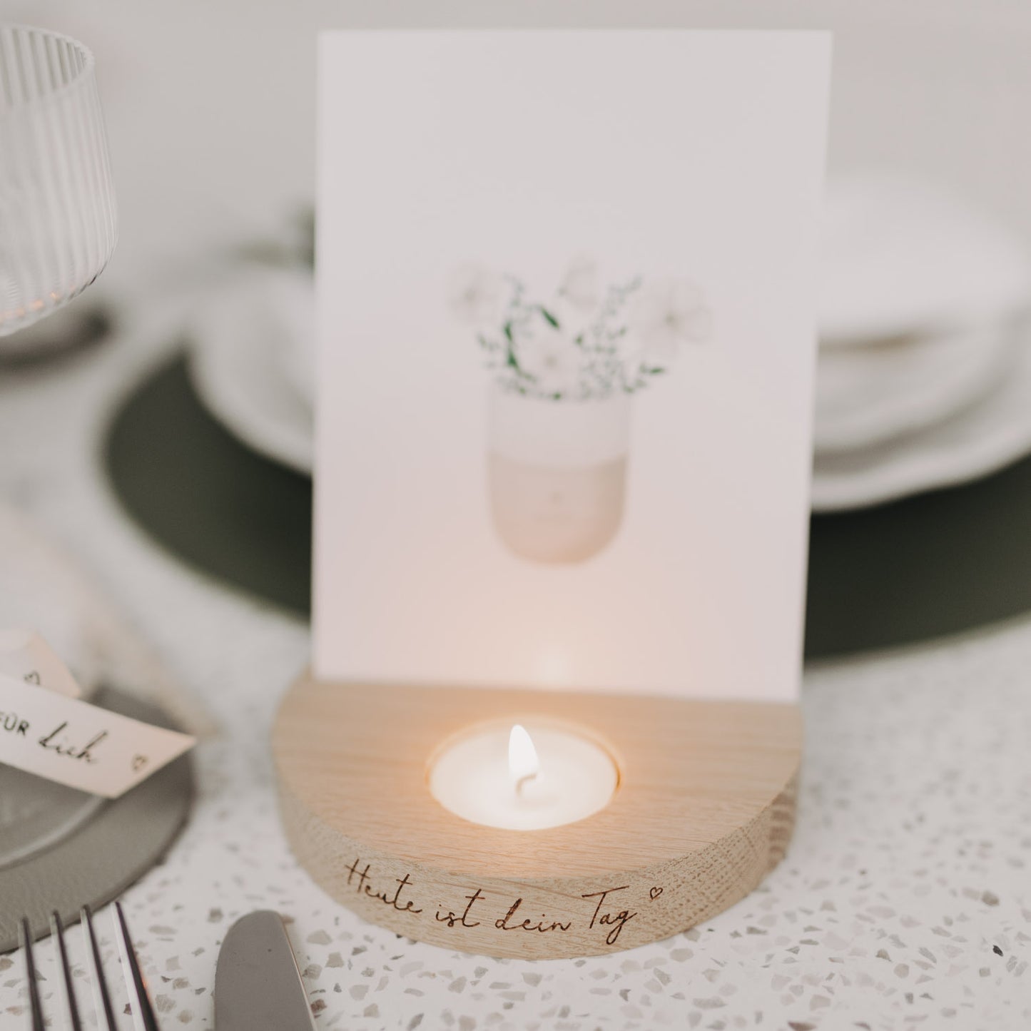 Teelicht-Kartenhalter „Heute ist dein Tag“ mit brennendem Teelicht und Karte auf gedecktem Tisch.