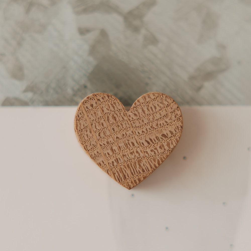Nahaufnahme eines herzförmigen Holzmagneten mit natürlicher Maserung