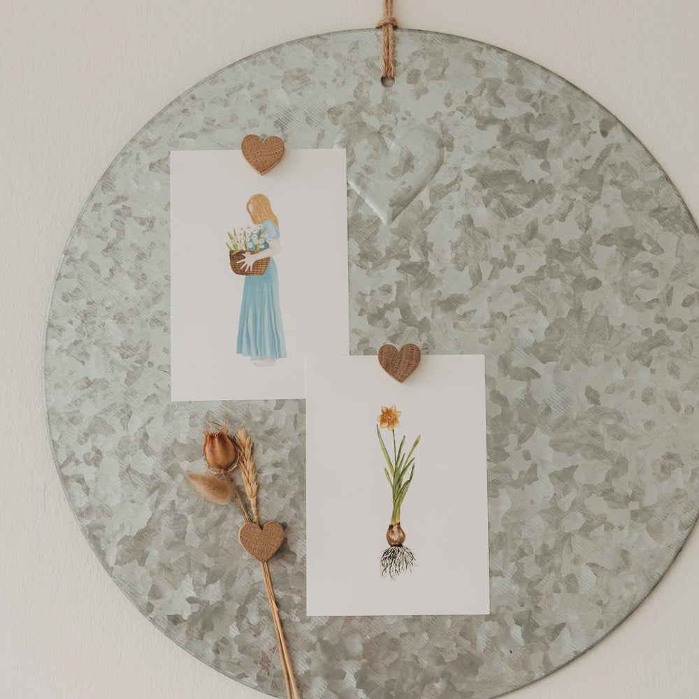 Herzmagnete aus Holz befestigen Karten und Trockenblumen an einer runden Magnettafel