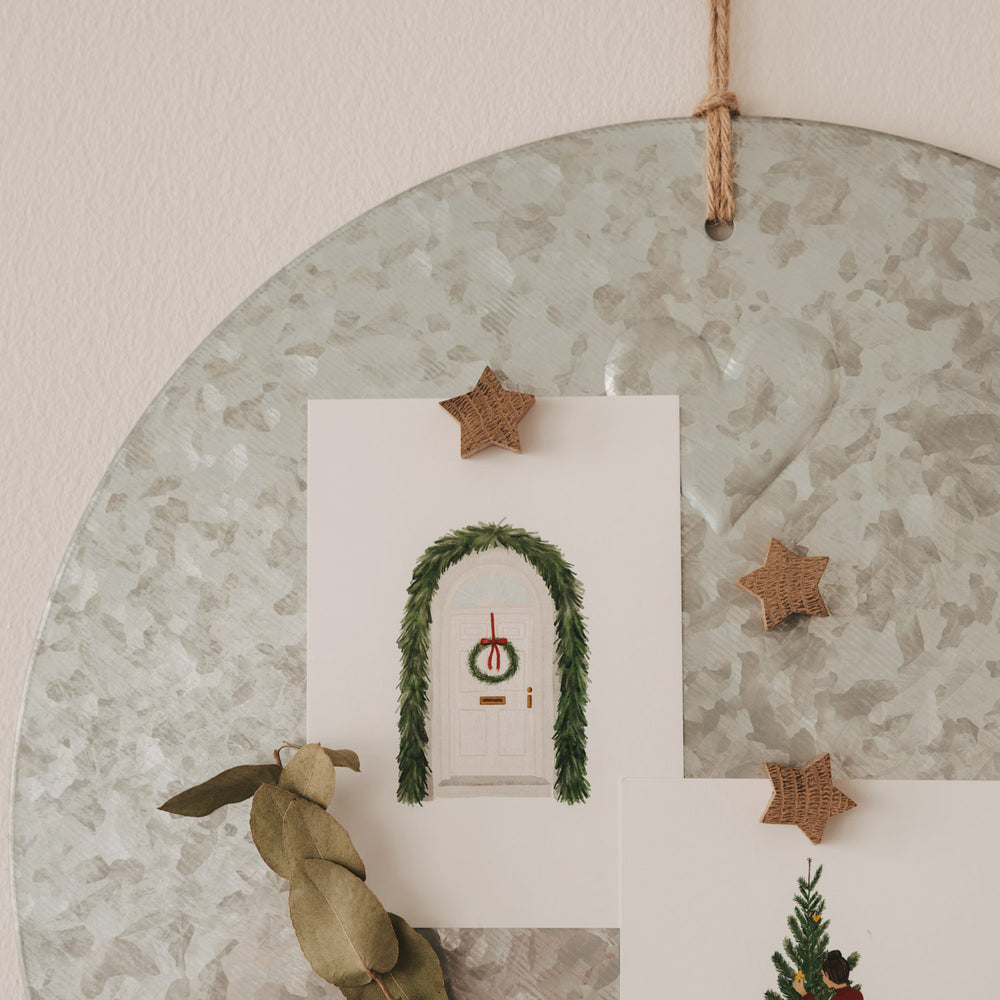 Sternmagnete aus Holz befestigen weihnachtliche Karten an einer runden Magnettafel