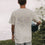 Person von hinten mit Yogamatte, weißes T-Shirt „go with the flow“ mit großem Rückendruck