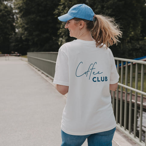 Frau trägt weißes Coffee Club T-Shirt beim Spaziergang, Rückenansicht