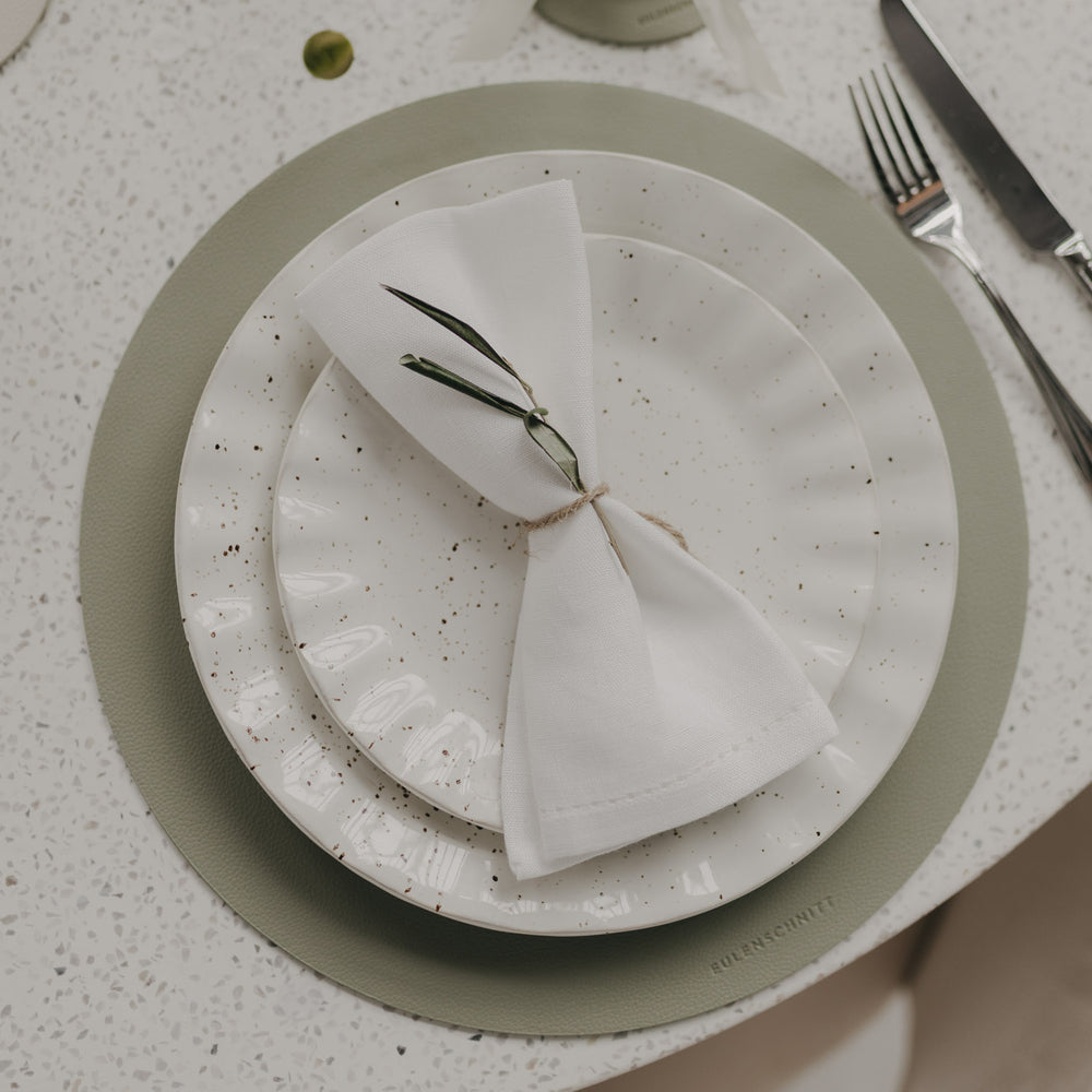 Helles grünes Platzset mit Herzprägung unter modernem Teller-Set