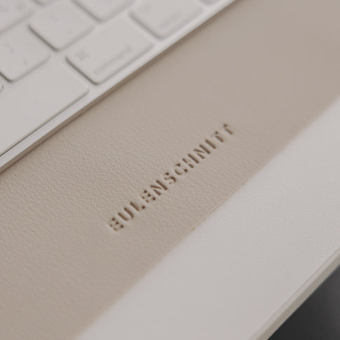 Detail Eulenschnitt Logo auf taupe Schreibtischunterlage, hochwertige Lederoptik sichtbar