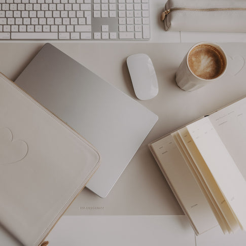 Creme Schreibtischunterlage mit Herz, Laptop, Maus und Notizbuch im minimalistischen Workspace