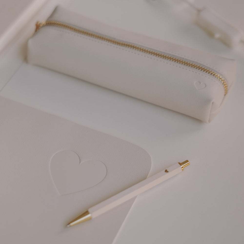 Detail creme Schreibtischunterlage mit Herz-Prägung, Stift und Federmäppchen in hellem Design