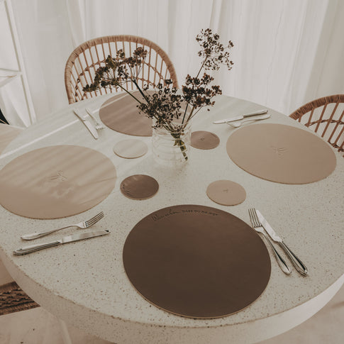 Wendbare Platzsets in Beige und Braun mit passenden Untersetzern auf gedecktem Esstisch