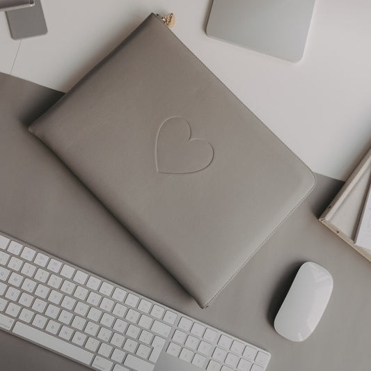 Graues Laptop Sleeve mit Herzprägung von Eulenschnitt auf modernem Schreibtisch mit Tastatur und Maus