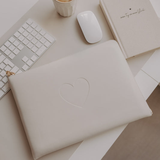 Laptophülle Creme mit Herzprägung auf Schreibtisch mit Tastatur, Maus und Notizbuch