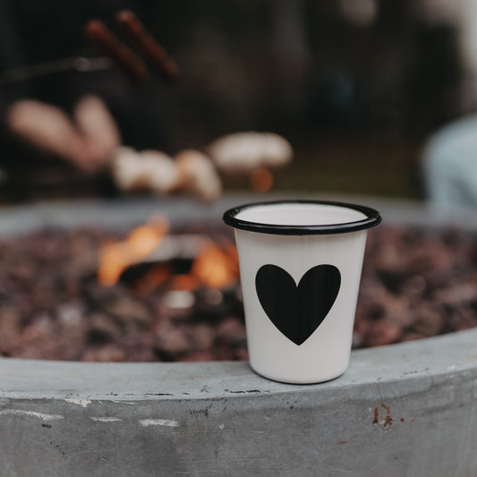 Emaille Tasse Herz in Off-White am Lagerfeuer – stilvoller Begleiter für Camping und Outdoor-Momente.