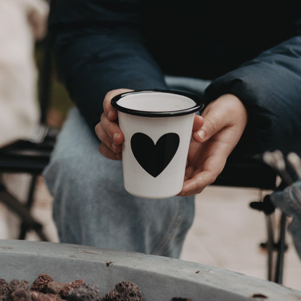 Emaille Tasse Herz wird in der Hand gehalten – robust, leicht und perfekt für unterwegs oder Camping.