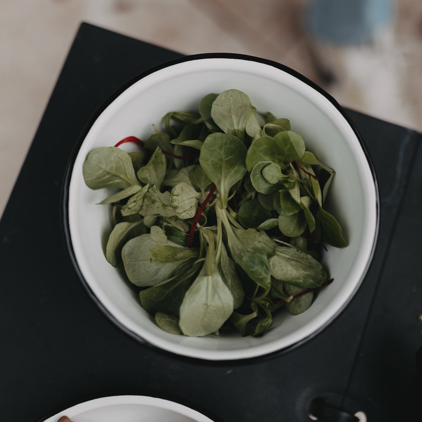 Emaille Schale Herz in Off-White von oben mit frischem Blattsalat, ideal für Garten oder Outdoor-Dining.
