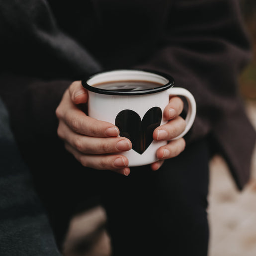 Emaille Tasse Herz wird mit beiden Händen gehalten – Wärme und Gemütlichkeit für kalte Tage.