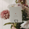 Herzstecker als Kartenhalter mit Grußkarte und rosa-weißen Blumen