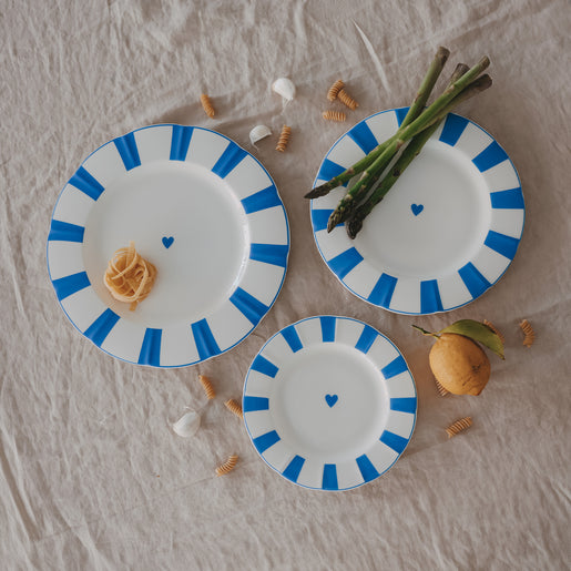 3 Teller aus Porzellan in verschiedenen Größen mit gewelltem Rand, hellblauen Streifen und Herzdetail, dekoriert mit Pasta und Spargel.
