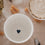 Weißer Herz-Becher von oben, neben Pasta und cremigem Gericht, stilvolle Keramik Tasse mit Herzmotiv