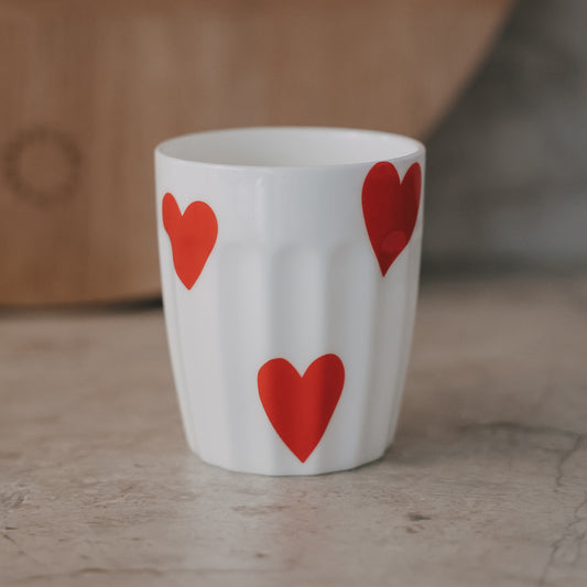 Weißer Keramikbecher mit roten Herzmotiven, modernes schlichtes Design