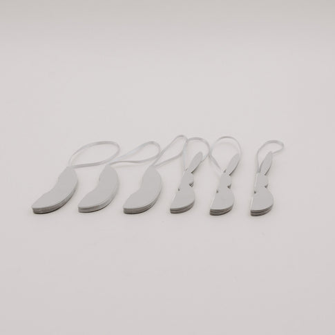 Sechsteiliges Set grauer Papieranhänger in Ei- und Hasenform, flach zusammengelegt.