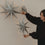 Graue Papiersterne in verschiedenen Größen mit Lichterkette als minimalistische Weihnachtsdekoration