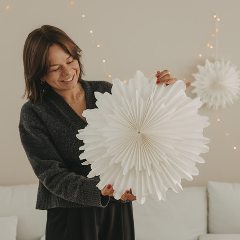 Weiße Papierschneeflocke 45 cm mit filigraner Fächerstruktur in den Händen gehalten