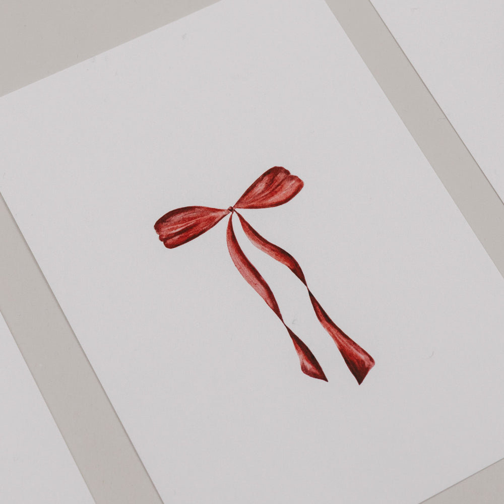 Minimalistische Weihnachtskarte mit roter Schleife auf weißem Hintergrund