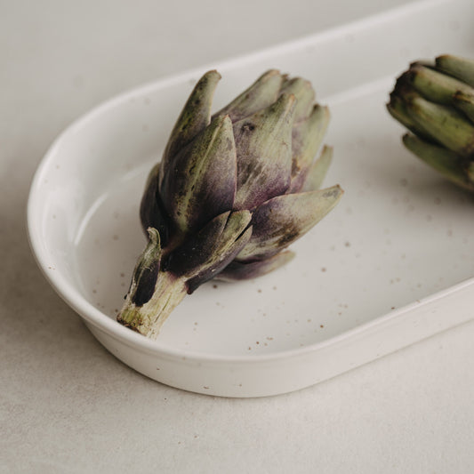 Zwei Artischocken auf großen und kleinen Calma Servierschalen angerichtet