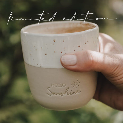 Keramikbecher „Hello Sunshine“ Limited Edition draußen gehalten, Mini Mug im Natursetting