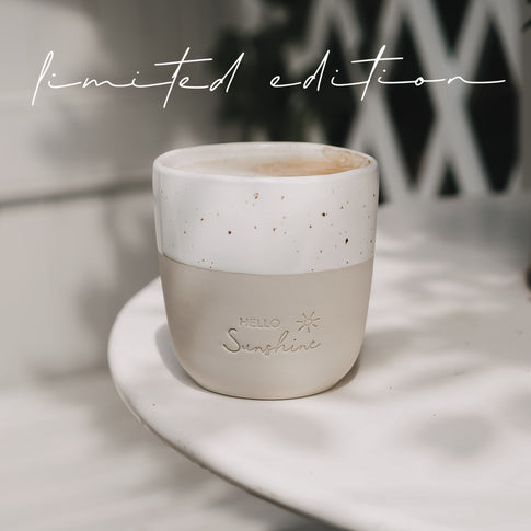 Keramikbecher „Hello Sunshine“ Limited Edition auf Tisch, Mini Mug in Beige Weiß mit Sprenkelglasur