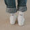 Weiße Kindersocken mit schwarzem Easy Peasy Schriftzug und umgeschlagener Jeans.