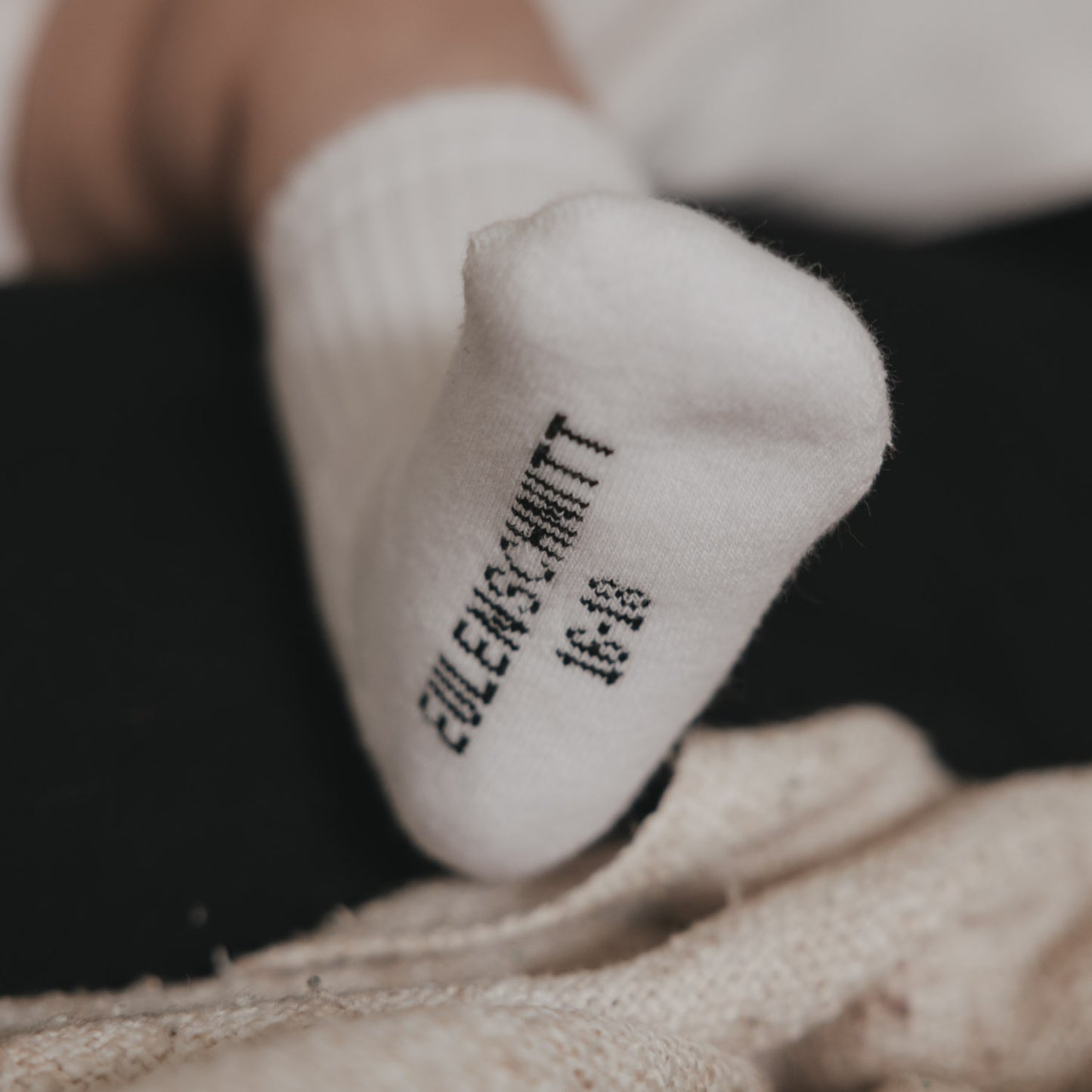 Detailansicht rutschfeste Baby Socken mit Schrift „Eulenschnitt“, weiche Baumwolle
