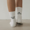 Weiße Socken Driving Home for Christmas mit schwarzem Schriftzug von hinten getragen
