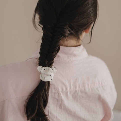 Geflochtener Zopf mit weißem Scrunchie mit schwarzen Herzen von hinten